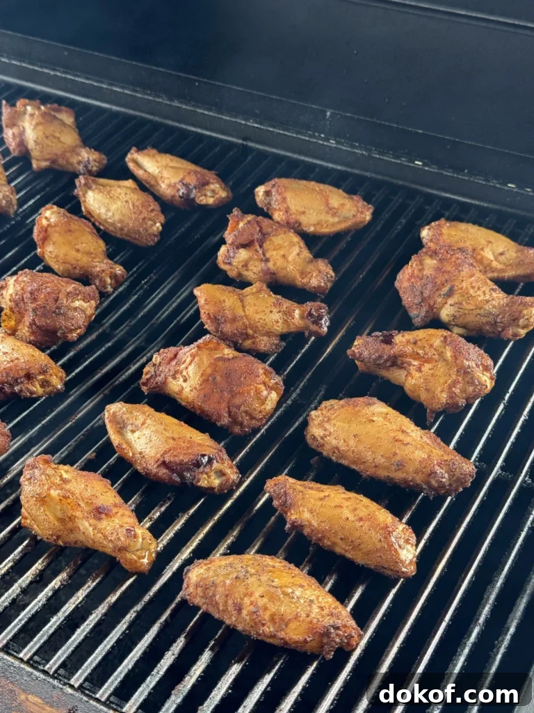 Chicken wings smoking on the grill with a light haze of smoke.