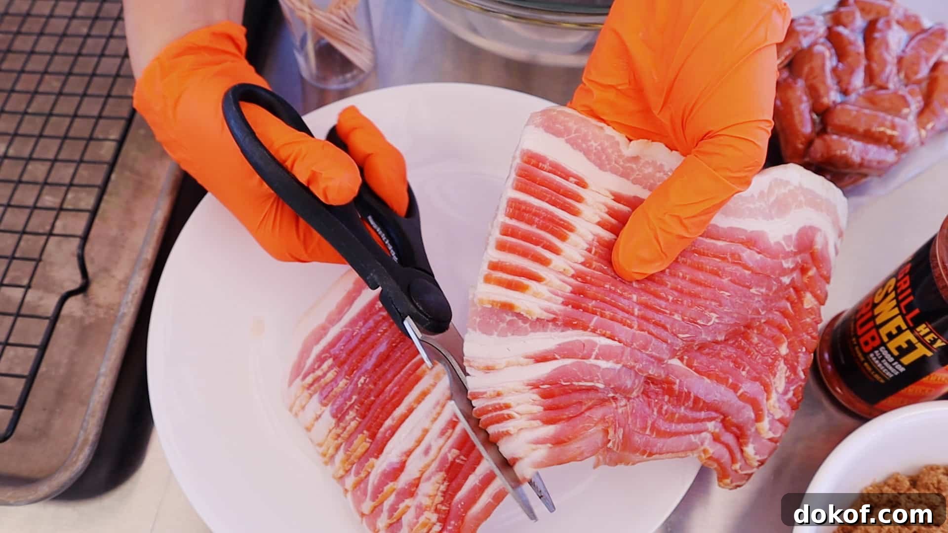 Bacon being cut into thirds with kitchen shears.