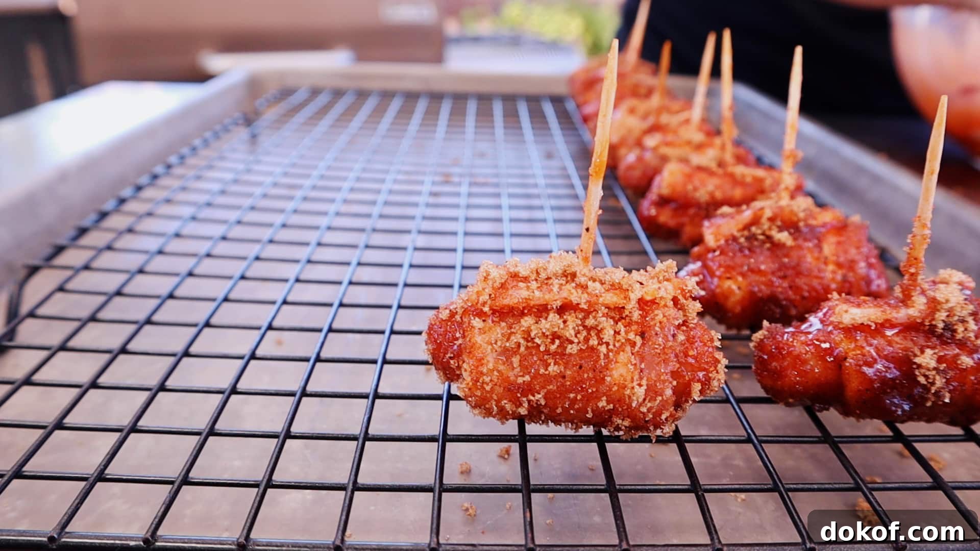 Seasoned bacon wrapped little smokies on a baking rack.