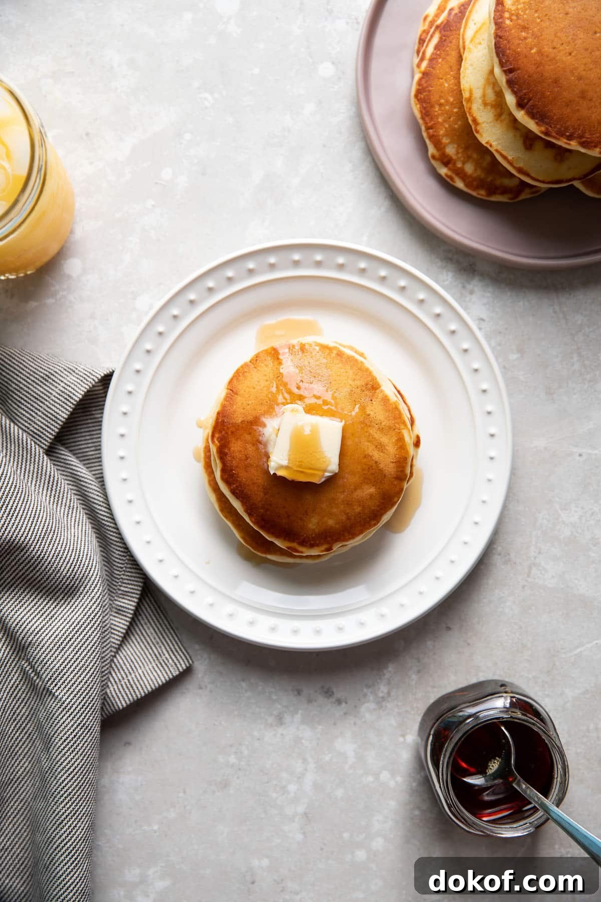 buttermilk pancakes on a plate with butter and maple syrup on top