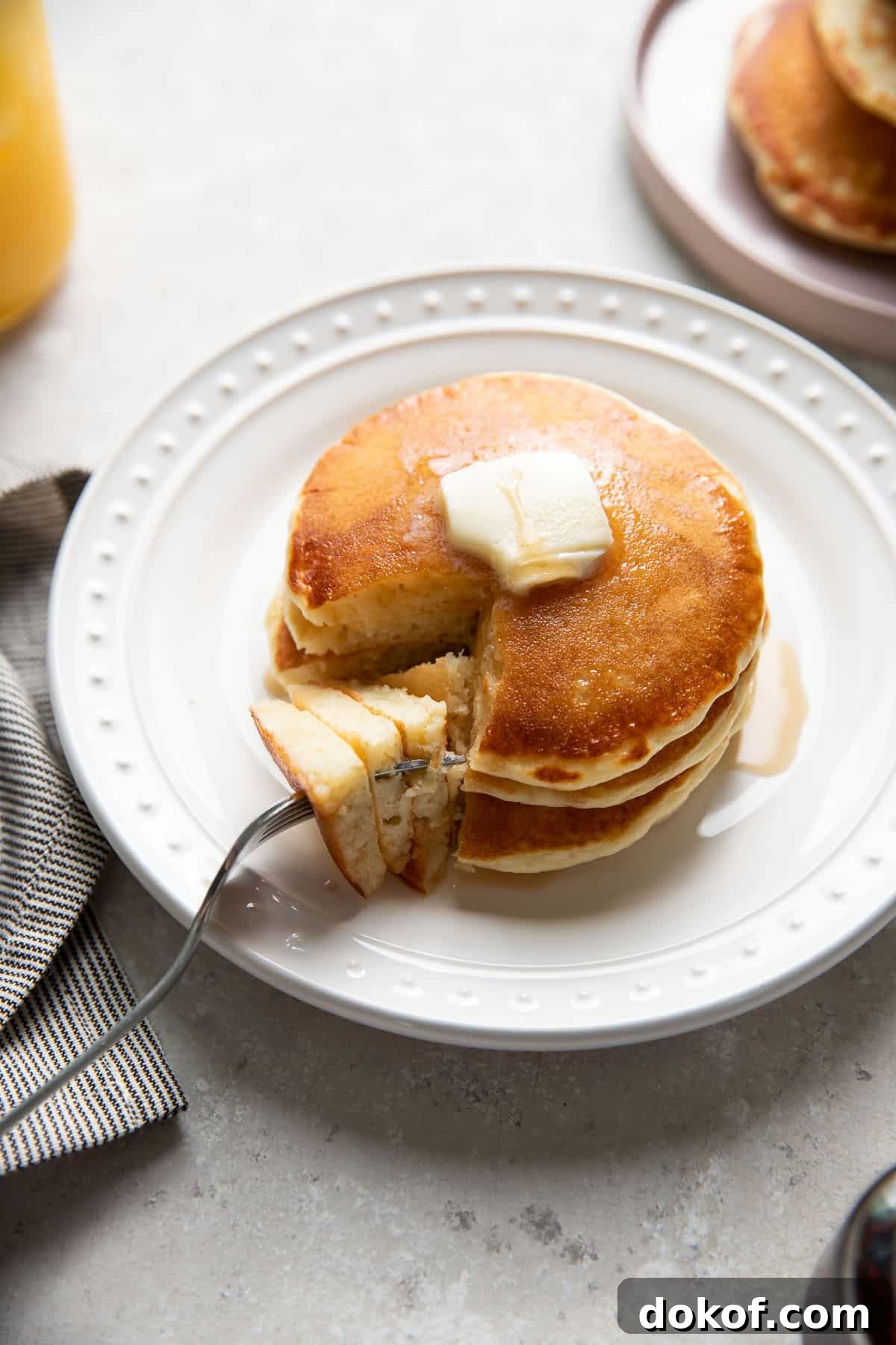 buttermilk pancakes on a plate with butter and maple syrup on top
