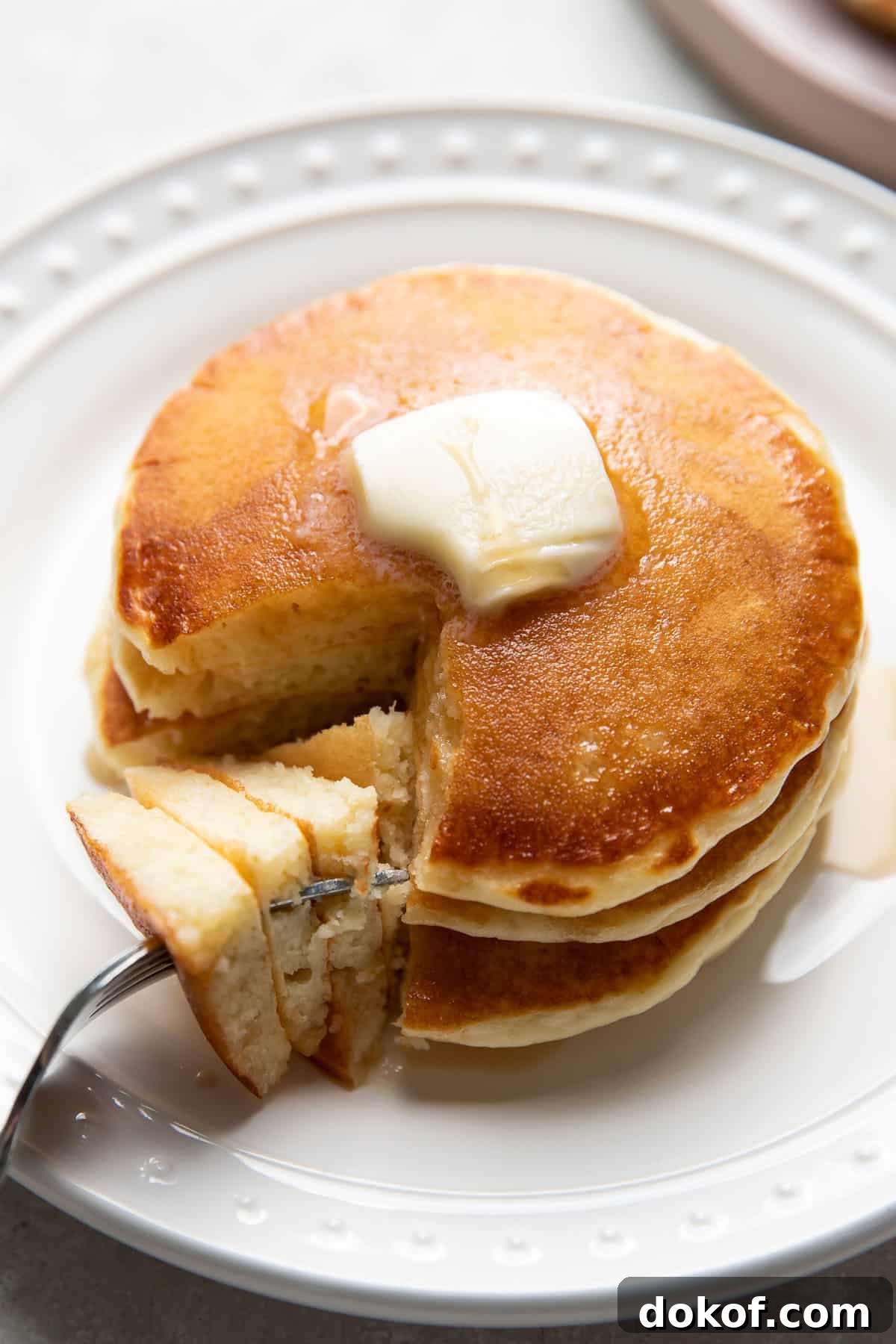 buttermilk pancakes on a plate with butter and maple syrup on top