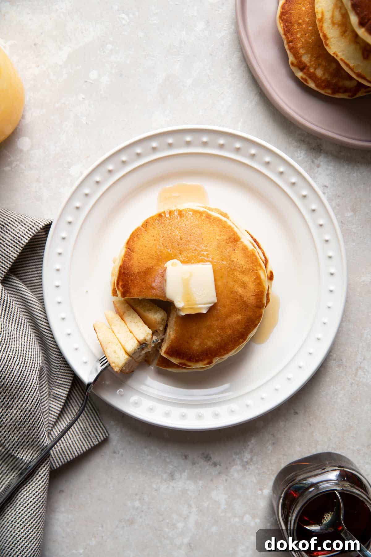 buttermilk pancakes on a plate with butter and maple syrup on top