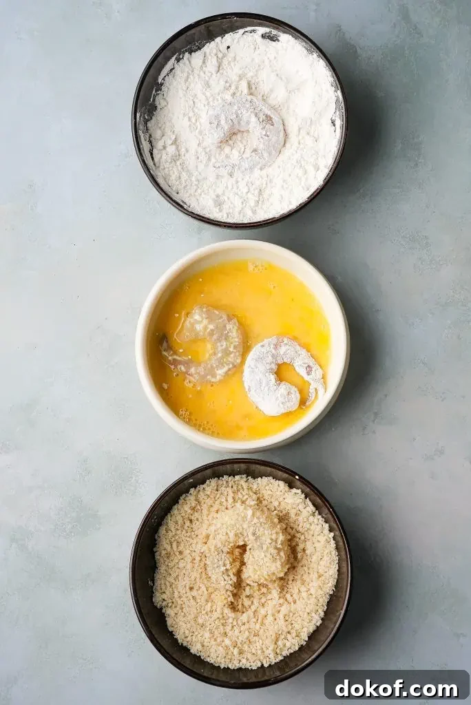 how to make bang bang shrimp Shrimp are shown being dredged in flour, dipped in beaten egg, and coated in breadcrumbs using three separate bowls for bang bang shrimp recipe.