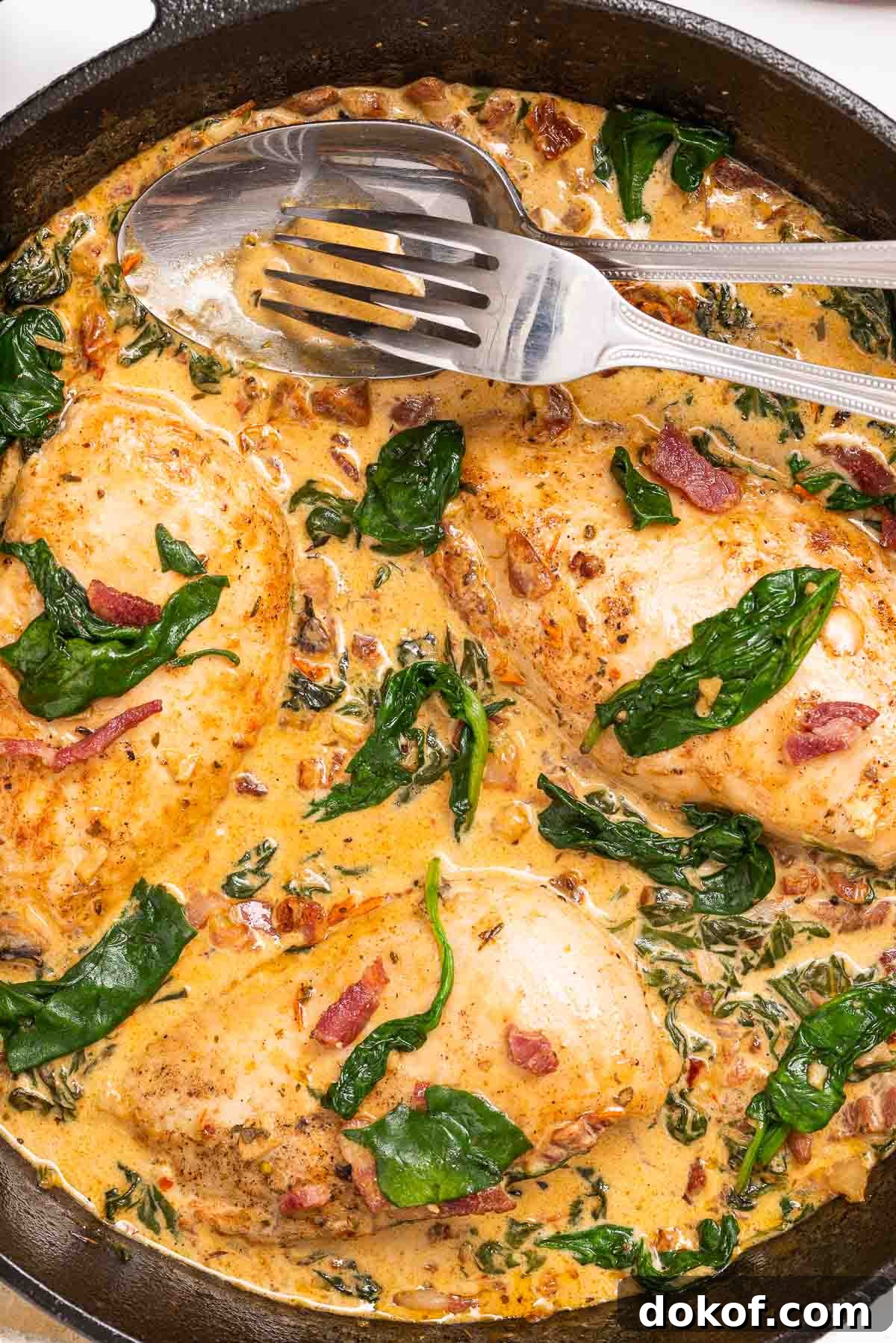 A pan with chicken, bacon, spinach and a creamy Tuscan sun-dried tomato sauce.