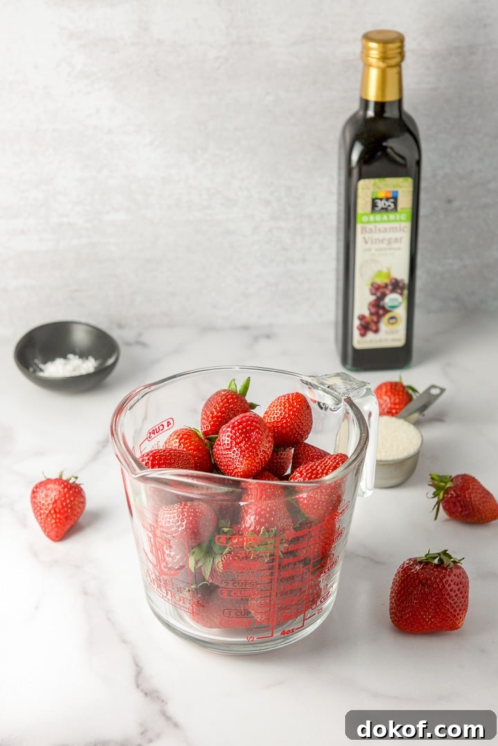 Strawberries in a measuring glass, sugar, corn starch and balsamic vinegar on a table