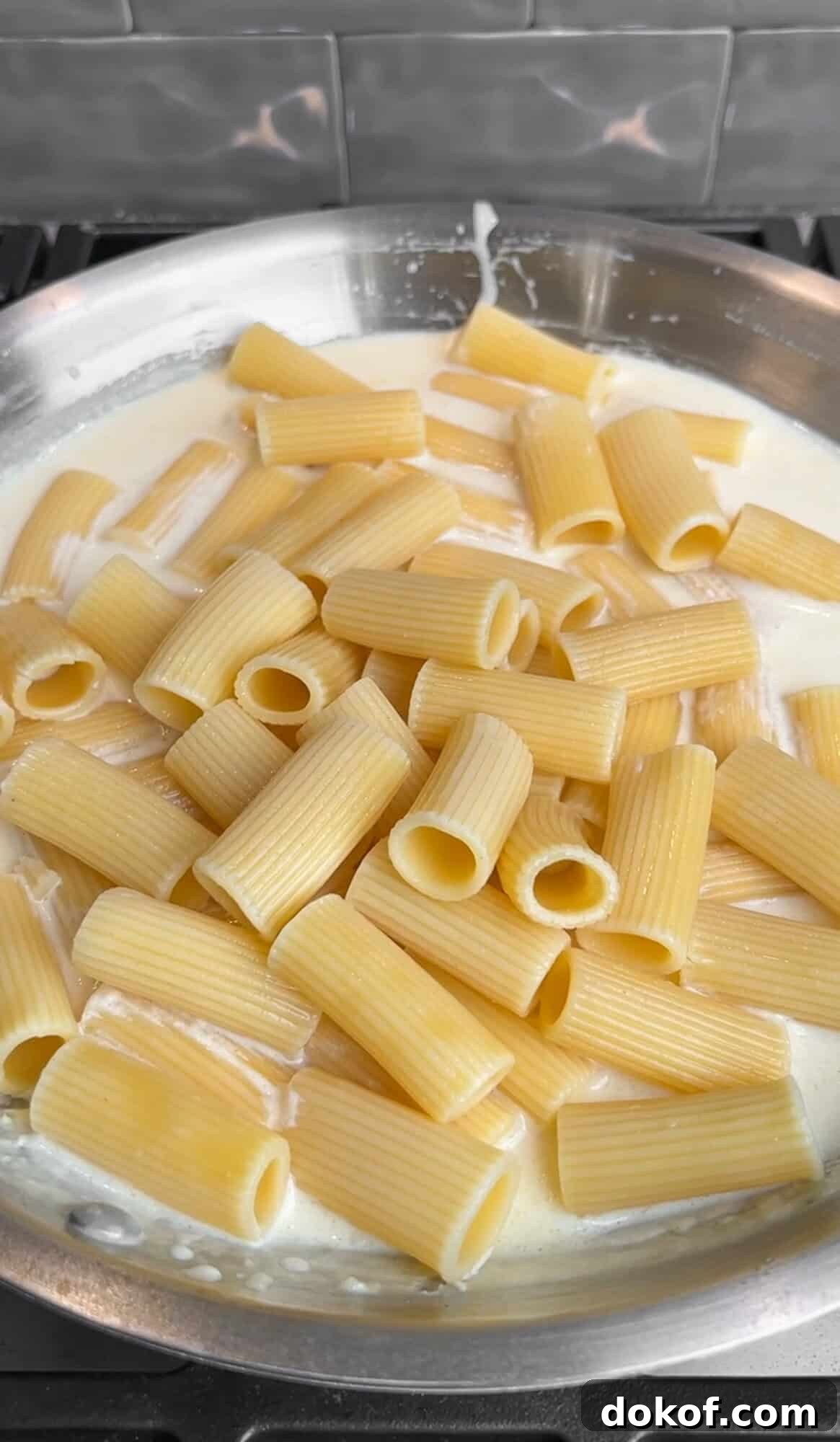 rigatoni being added to the creamy lemon pasta sauce