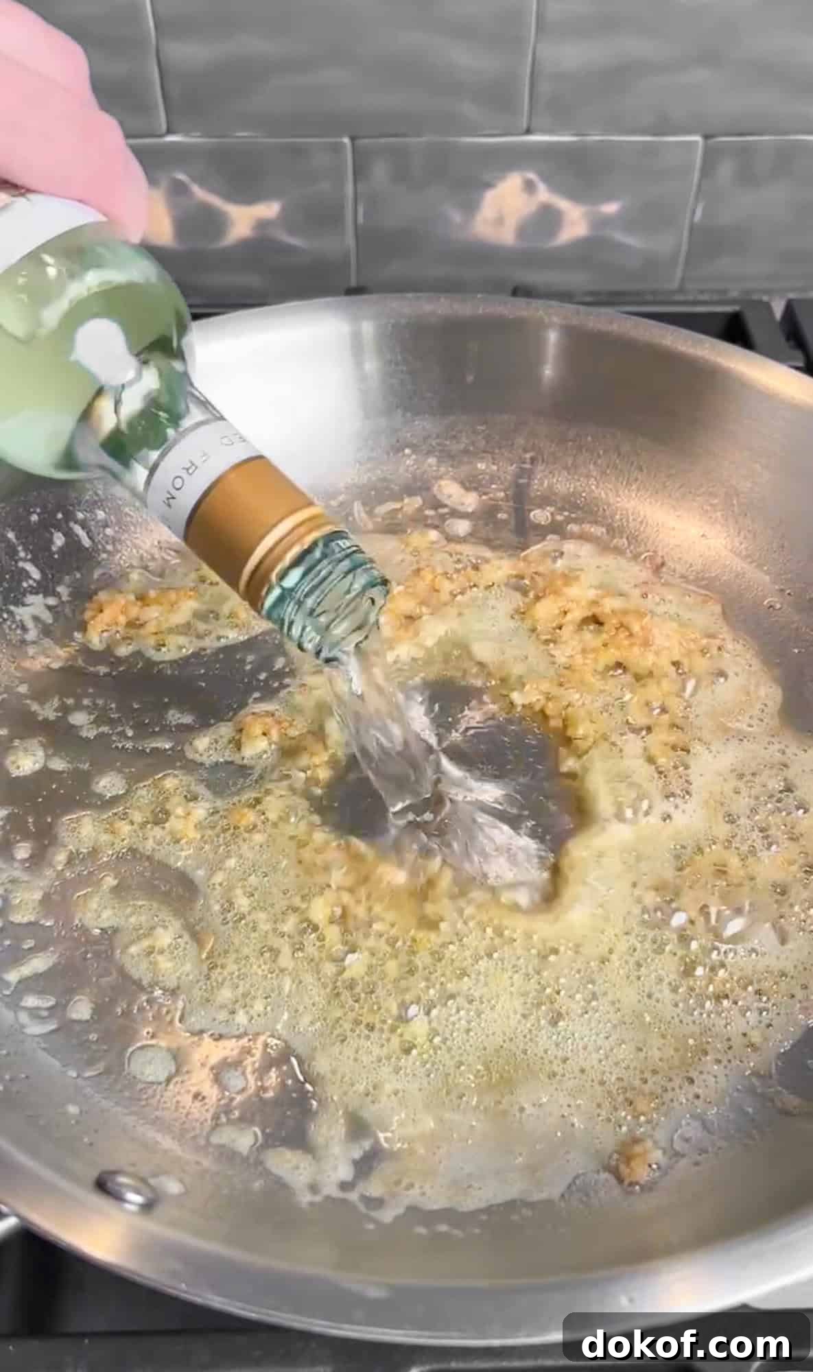 adding white wine to creamy lemon pasta