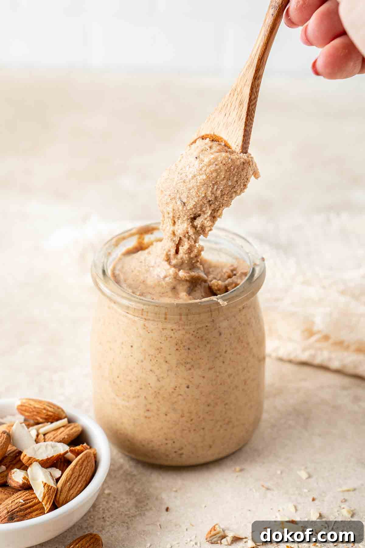 Homemade Almond Butter: Simple Recipe for Smooth, Creamy Spread 2 A spoonful of homemade almond butter from a jar.