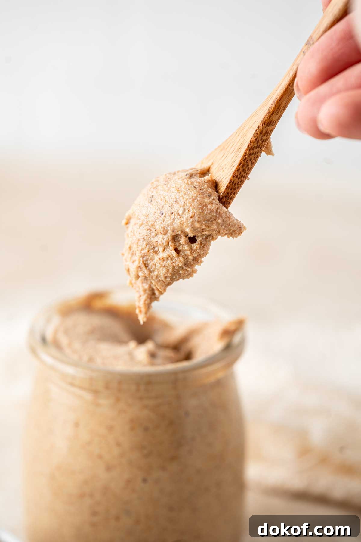 Homemade Almond Butter: Simple Recipe for Smooth, Creamy Spread 11 Close up of a spoon of almond butter being scooped from the jar.