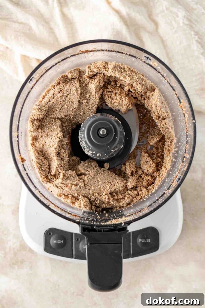 Homemade Almond Butter: Simple Recipe for Smooth, Creamy Spread 7 The almond butter halfway through in the food processor.