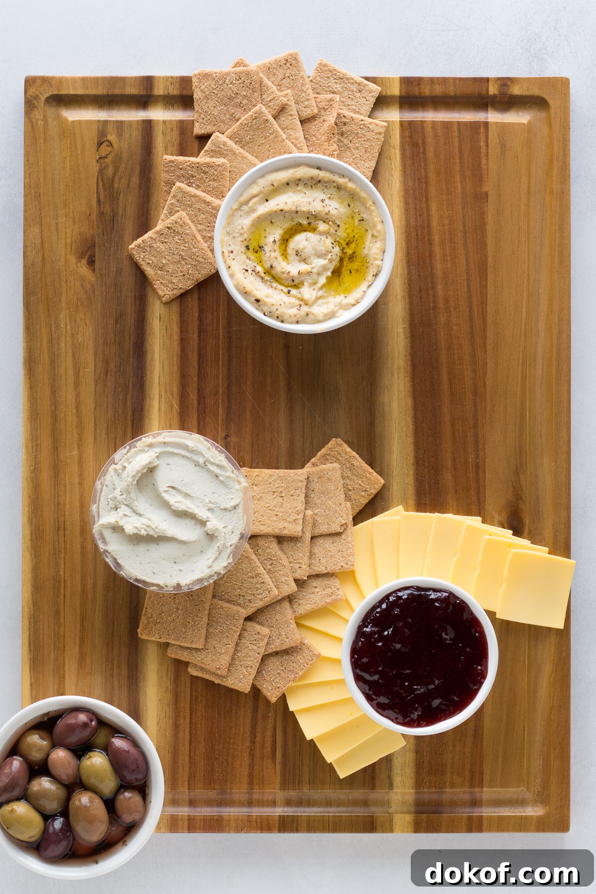Vegan Cheese Board with crackers, cheese, jams, and olives by Flora & Vino