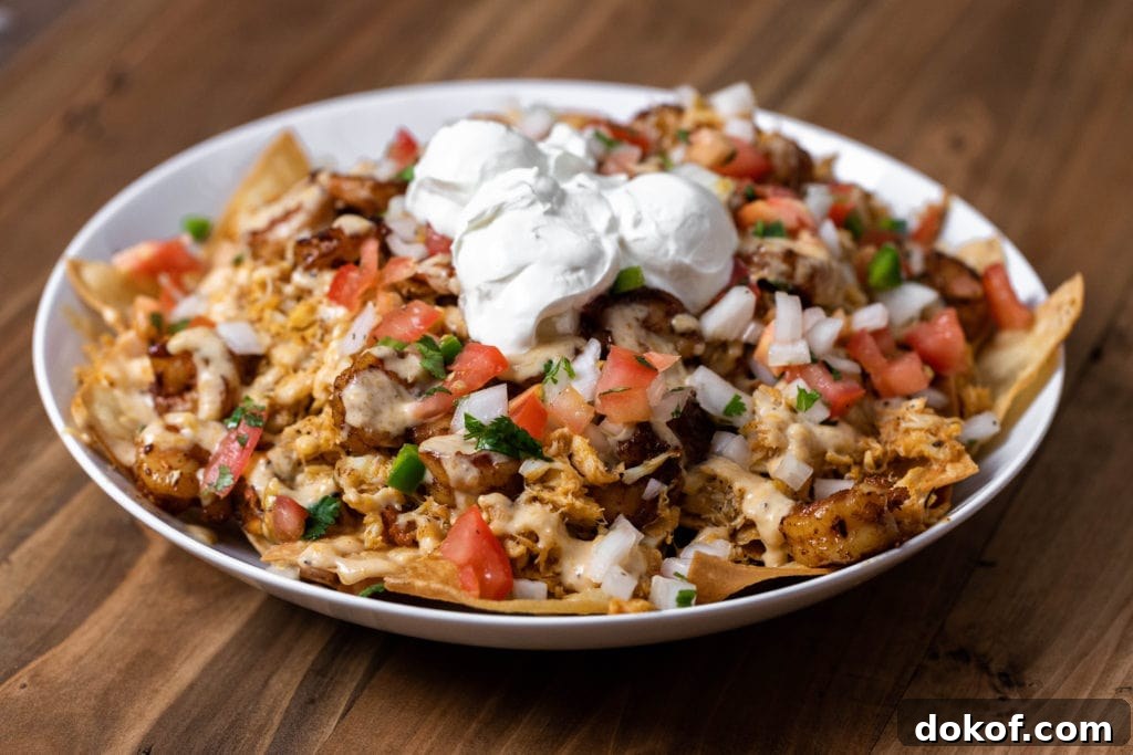 plate of seafood nachos topped with pico de gallo, sour cream and cilantro