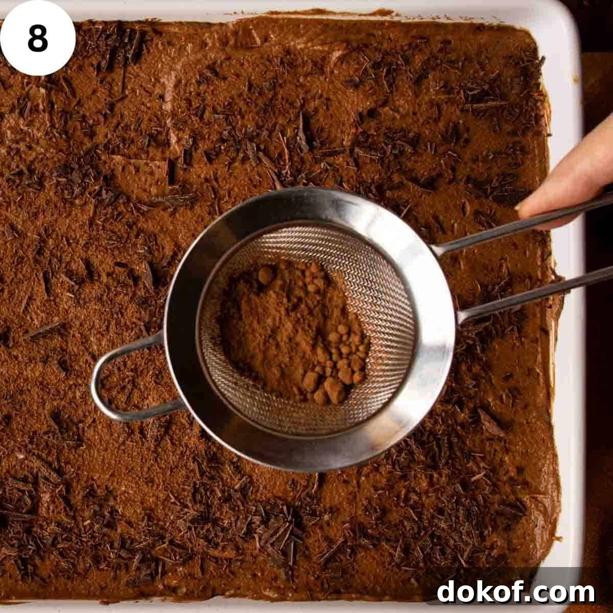 Decadent Chocolate Tiramisu Recipe for Coffee Lovers 11 Cocoa being sprinkled onto a dessert.