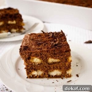 Decadent Chocolate Tiramisu Recipe for Coffee Lovers 14 Large square piece of Chocolate Tiramisu on a white plate.