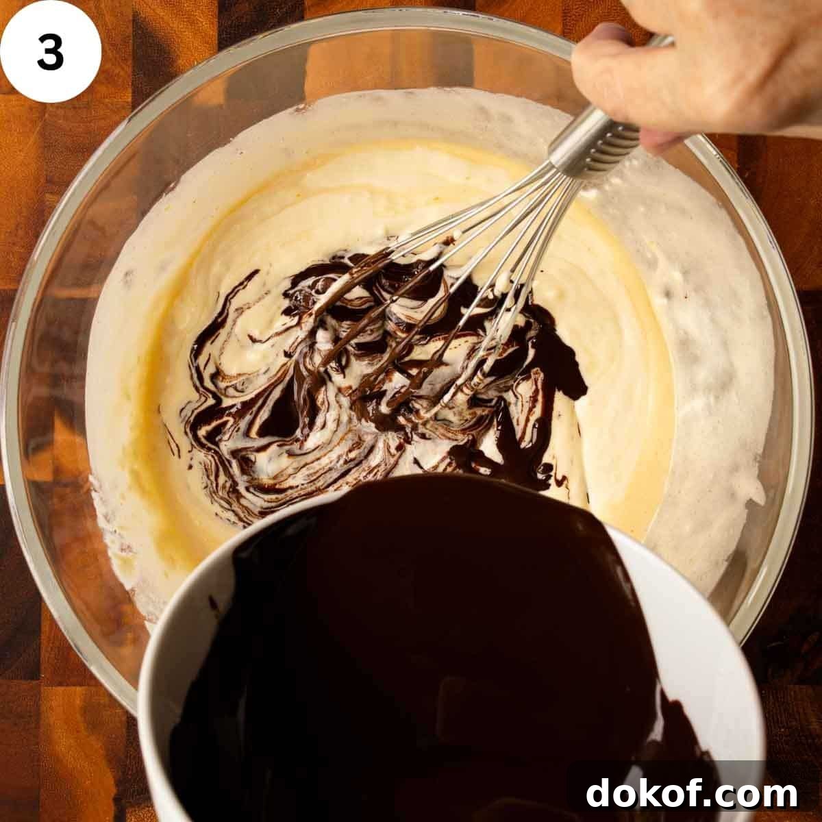 Decadent Chocolate Tiramisu Recipe for Coffee Lovers 6 Melted chocolate being whisked into creamy yellow mixture.