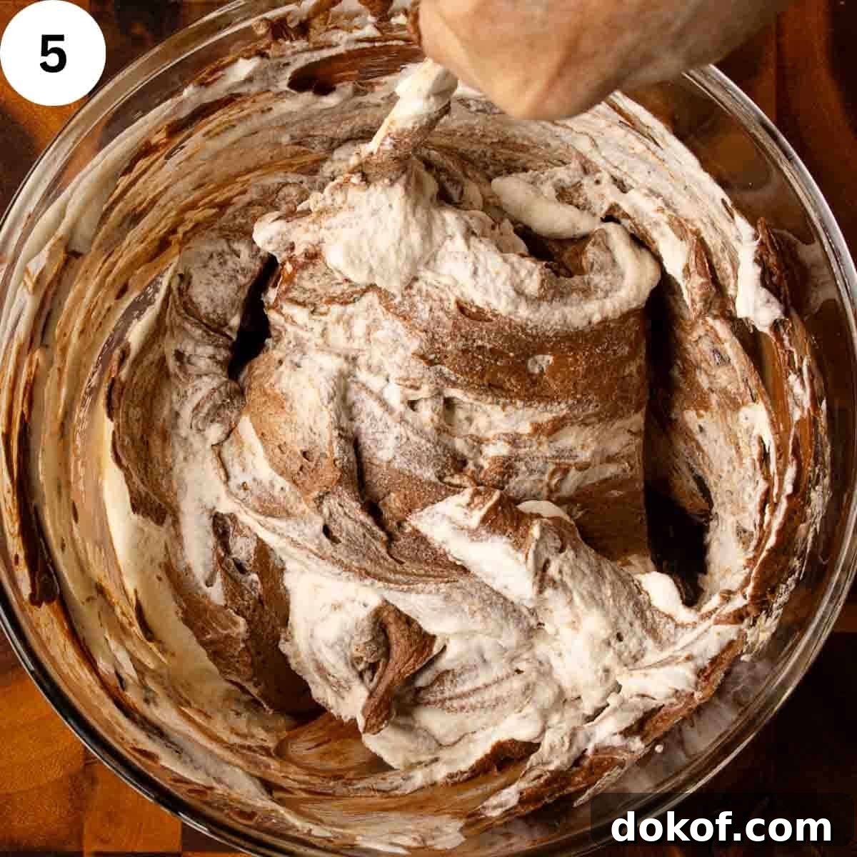 Decadent Chocolate Tiramisu Recipe for Coffee Lovers 8 White and chocolate mixtures being folded together in a bowl.