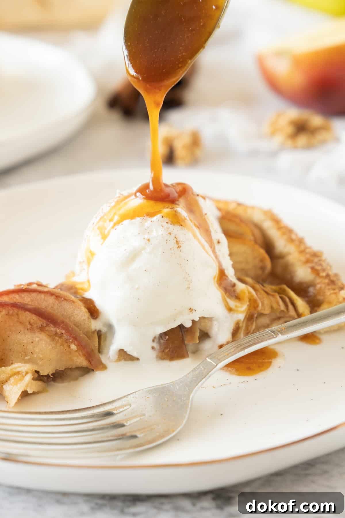 Rustic Apple Galette Recipe: Simple Homemade Apple Tart 12 Pouring caramel over slice of apple galette a la mode on a white plate. A silver fork.