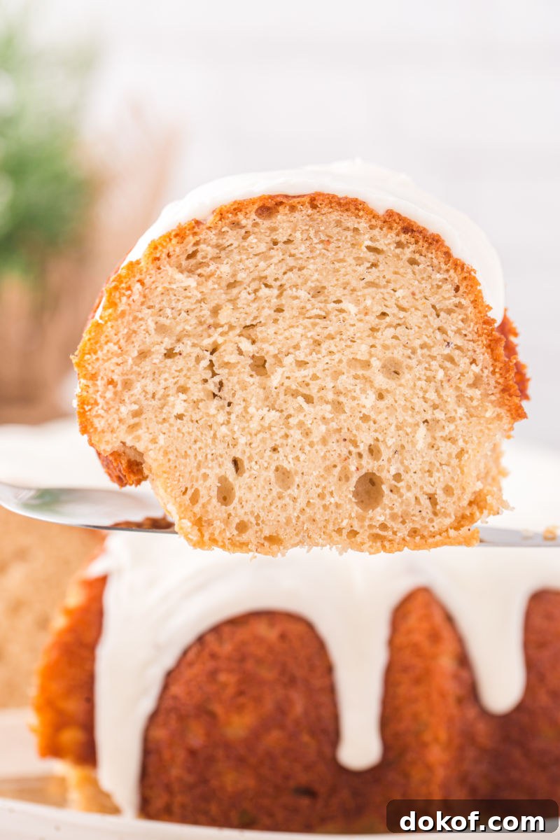 slice of eggnog bundt cake on a cake server over the cake