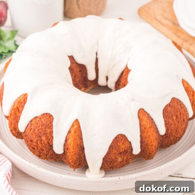 square image of eggnog bundt cake topped with eggnog glaze on a serving plate
