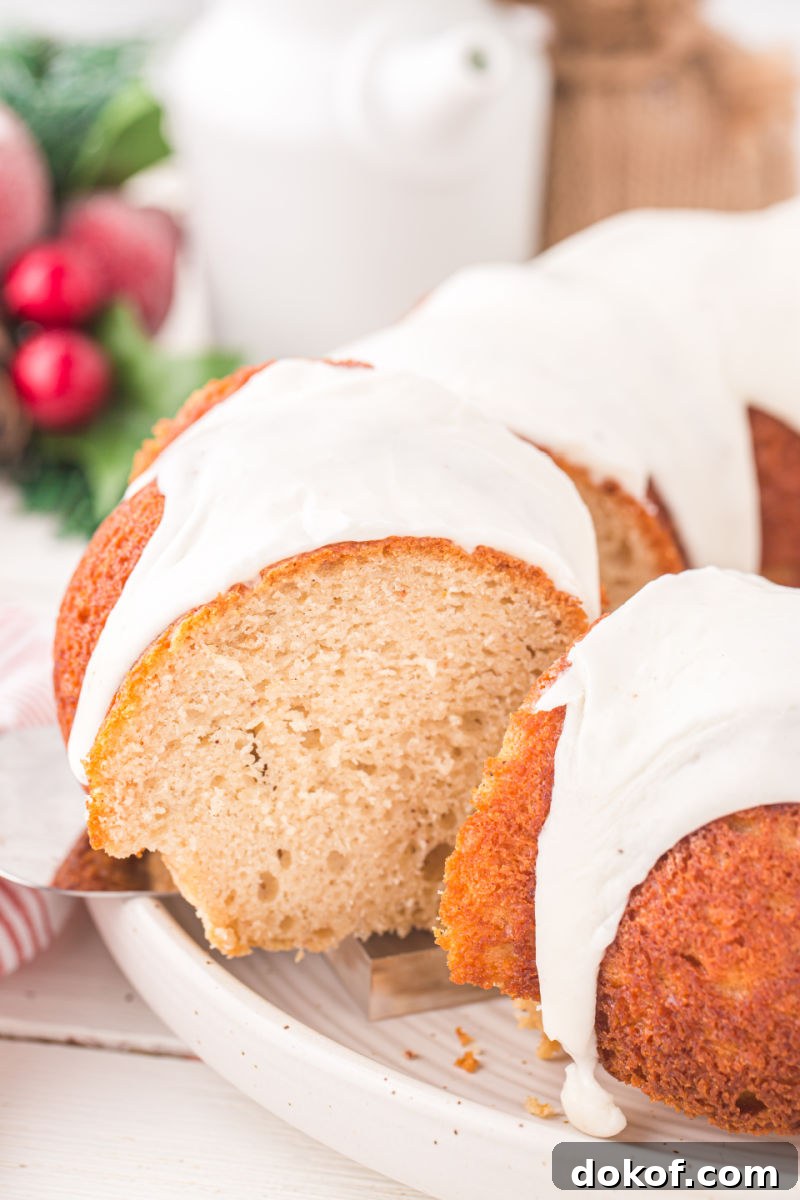 slice of eggnog bundt cake being lifted from the cake on a cake server