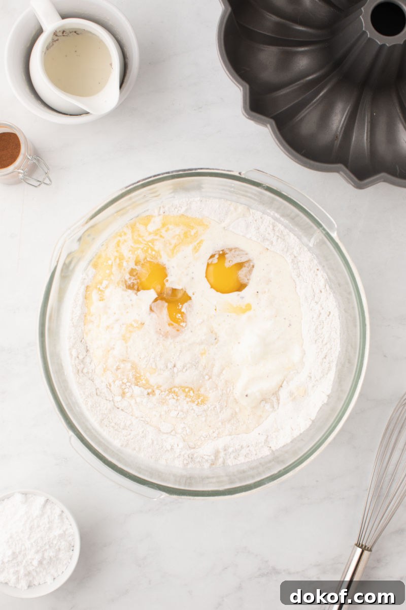 eggs, melted butter, and eggnog added to a mixing bowl with cake mix and ground nutmeg