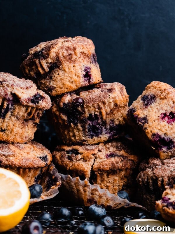 Tall blueberry muffins stacked on top of each other.