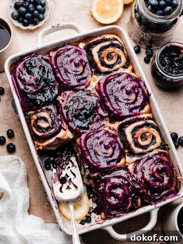 A pan of blueberry frosted blueberry cinnamon rolls.