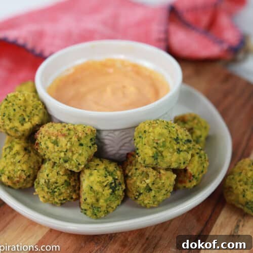broccoli tots on a white plate with a white bowl of dipping sauce