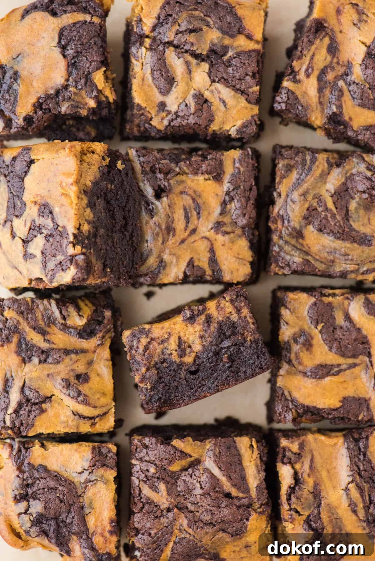 pumpkin brownies cut into 12 squares on brown parchment paper