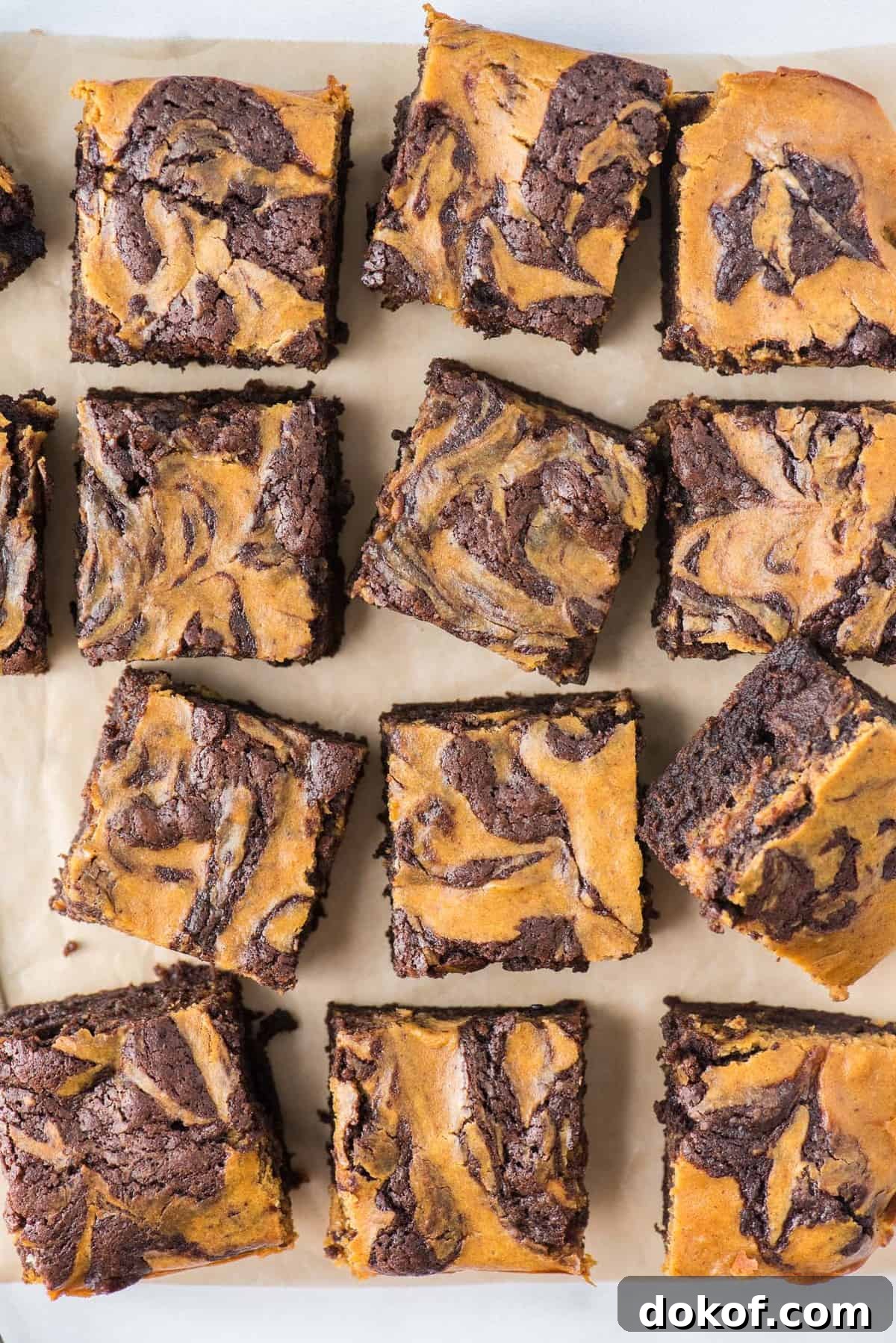 pumpkin brownies cut into 12 squares on brown parchment paper
