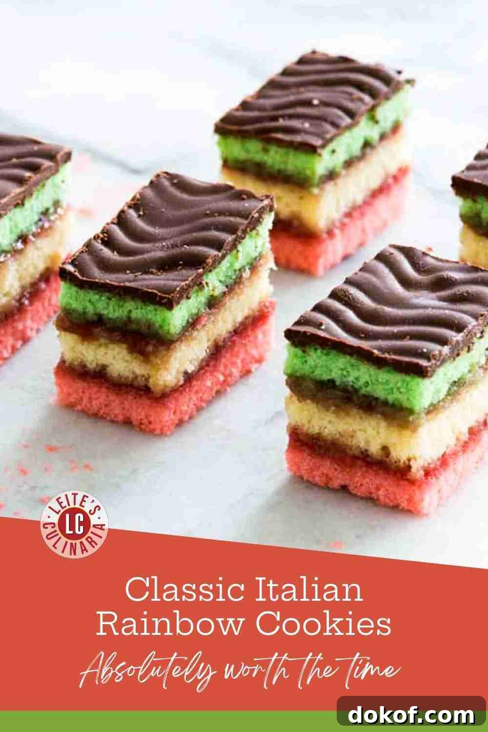 Stacked Italian rainbow cookies with green, yellow, and pink layers, raspberry jam, and a chocolate topping.