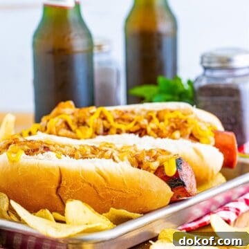 A pair of Polish Sausage Sandwich Recipe sandwiches with grilled sausage, caramelized onions, and yellow mustard on toasted hoagie rolls.
