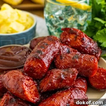 Smoked kielbasa pieces glazed with BBQ sauce on a plate.