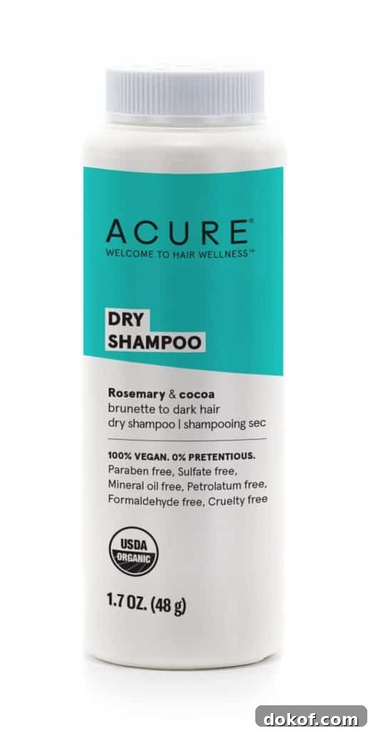 A bottle of Acure dry shampoo with a teal label.