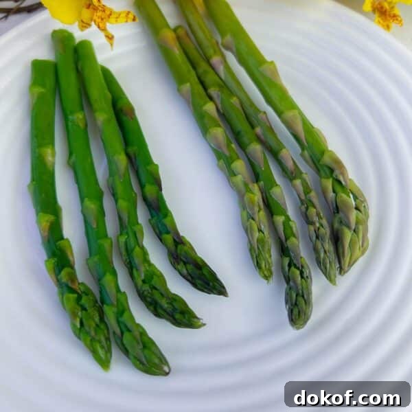 four spears blanched asparagus four spears raw asparagus on plate