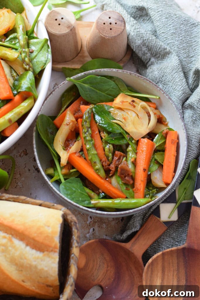 Spring vegetable stir fry in a serving bowl with bread on the side.