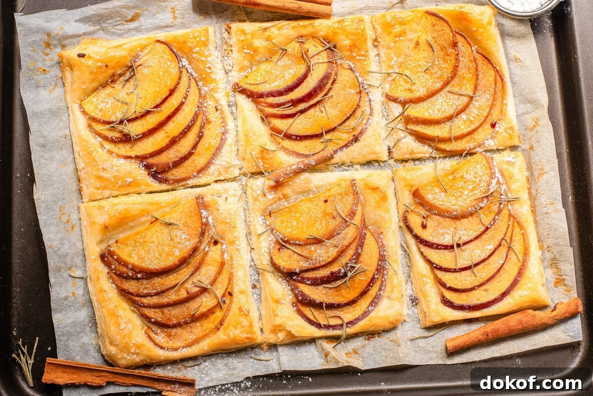 Flaky Peach Puff Pastry Tart Recipe for Summer Dessert 11 An overhead image of peach puff pastries on a parchment sheet.
