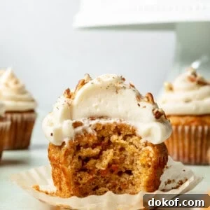 Carrot cake cupcake with a bite taken out.