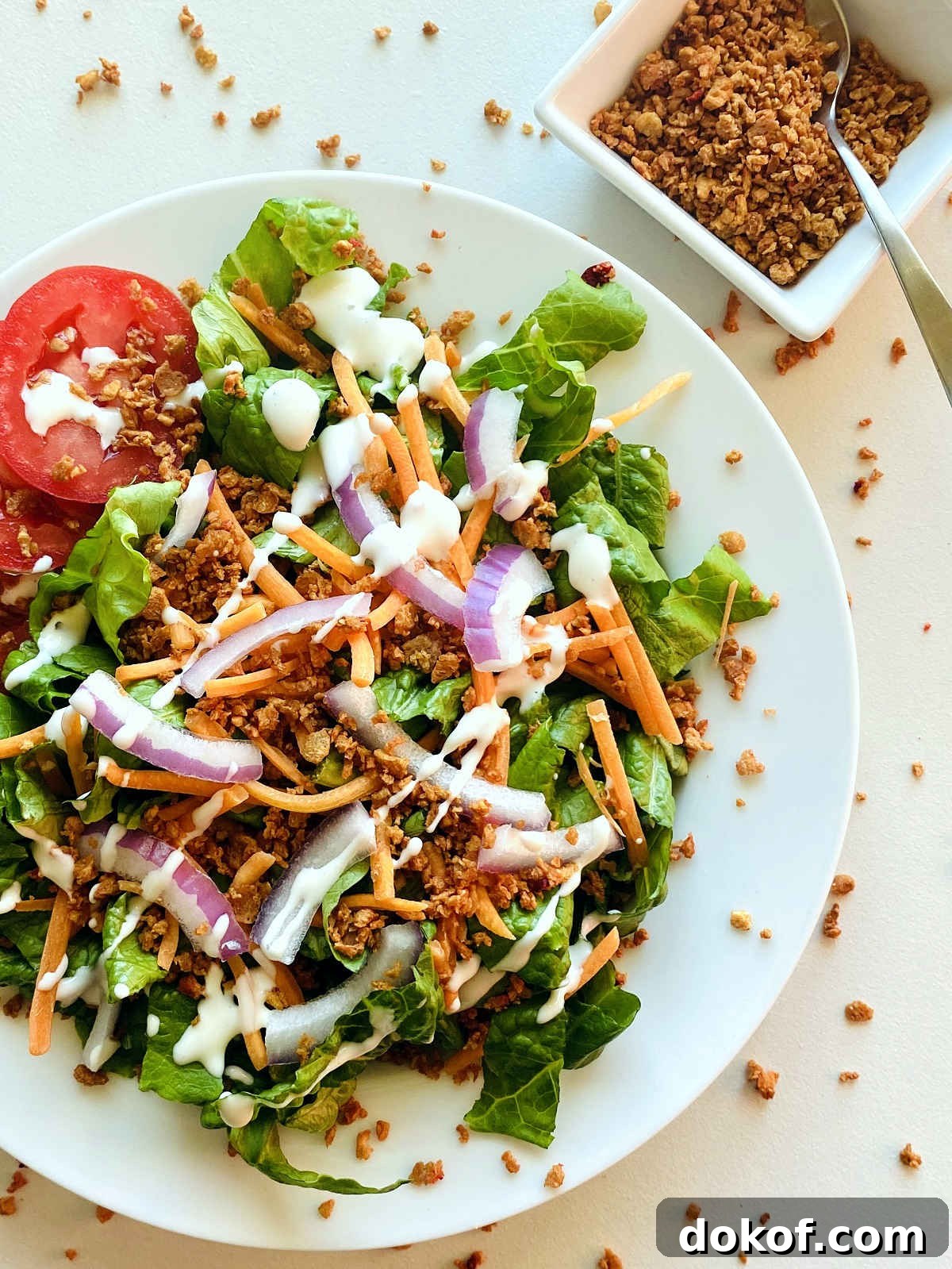 vegan bacon bits in white dish next to salad with ranch dressing and bacon bits