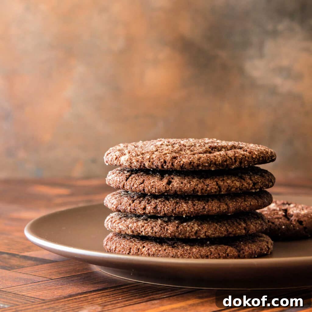 A stack of brown cookies on a brown plate shot on a wooden background with a worn bronze backdrop.