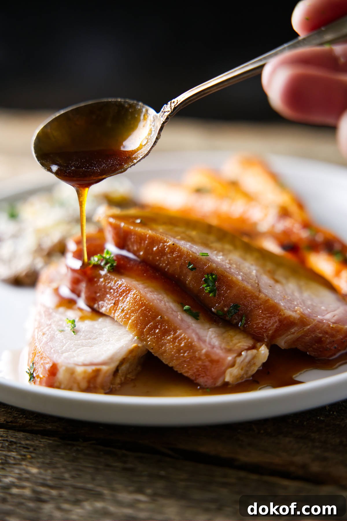 drizzling glaze on sliced pork loin