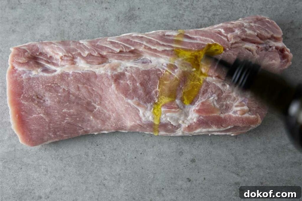 adding oil to the pork loin