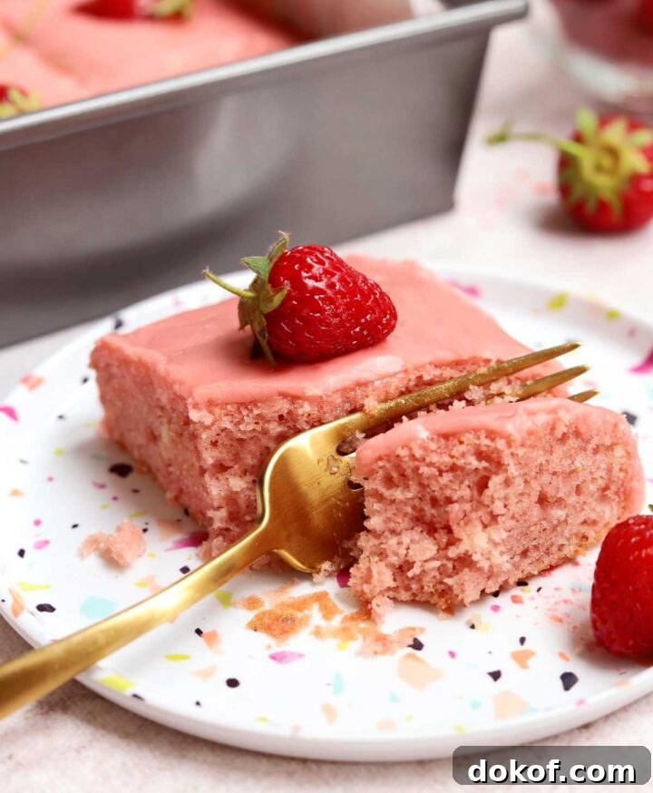 Fresh Strawberry Sheet Cake Recipe — Moist, Fruity Dessert 22 slice of strawberry sheet cake on a plate with bite and fork