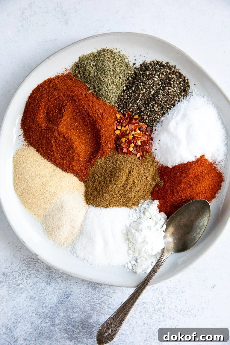 White plate filled with all the ingredients to make taco seasoning.