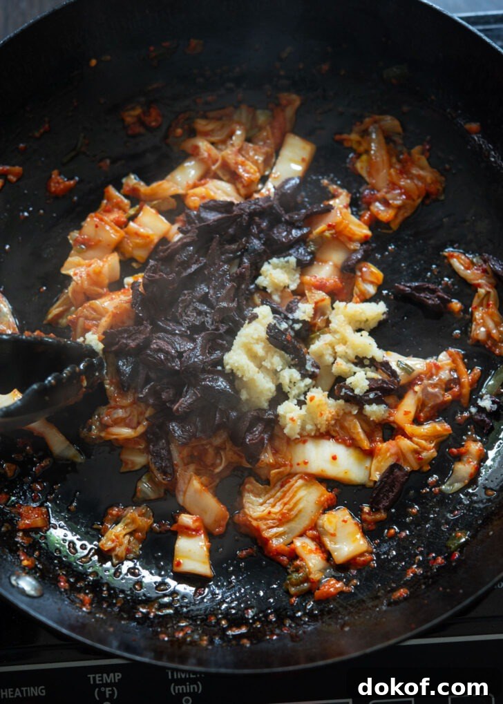 Olives and garlic are added to fried kimchi to make kimchi olive pasta. 