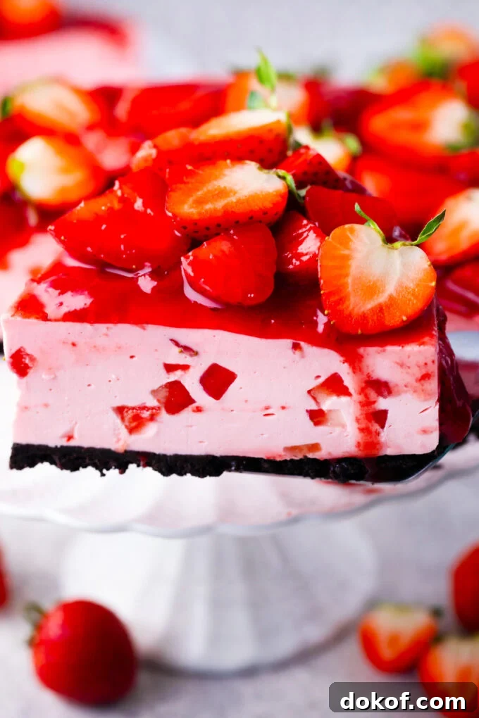 A slice of no-bake strawberry cheesecake with strawberry topping.