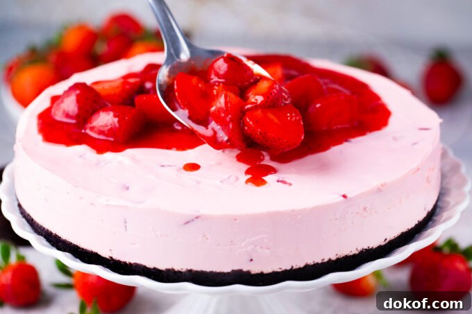 Adding strawberry topping on top of no-bake strawberry cheesecake.