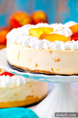 No bake peach cheesecake on a cake stamnd.