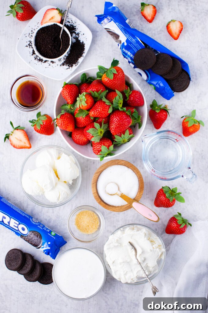 Overhead shot of no-bake strawberry cheesecake ingredients in bowls on a table.